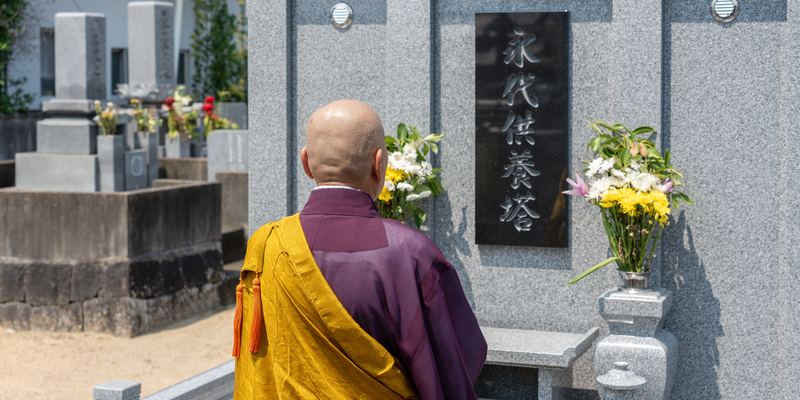 永代供養塔の前で読経する僧侶